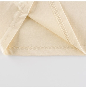 Vue macro détaillée de l'ourlet du t-shirt beige avec double couture de précision