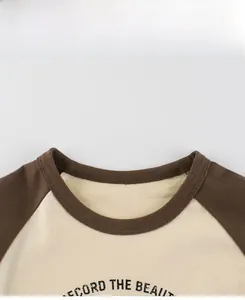 Détail de l'encolure raglan sur un t-shirt en coton pour enfant avec coutures contrastées