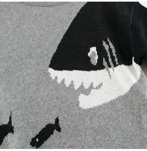 Détail du pull en maille grise avec motif requin et col rond côtelé de haute qualité