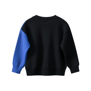 Détail d'un pull en maille pour garçon avec poignets côtelés et design contrasté bleu et noir