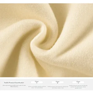 Gros plan sur un tissu en maille beige montrant une texture fine et une qualité douce