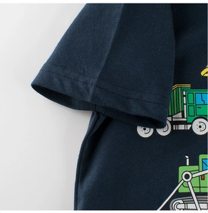 Gros plan détaillé d'un t-shirt enfant bleu marine avec coutures et motif de camion cartoon