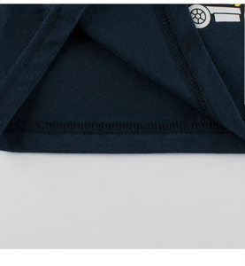 Détail de la couture et de l'ourlet du t-shirt en coton bleu marine avec motif de chantier