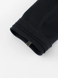 Détail des poignets en maille élastique et des coutures d'un t-shirt enfant noir