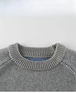 Détail du col d'un pull en maille gris pour garçon avec une finition en côtes serrées