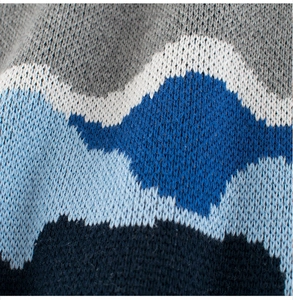 Gros plan d'un pull en tricot pour garçon avec des motifs de vagues jacquard bleu et blanc
