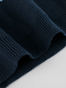 Gros plan du poignet d'un pull en tricot bleu marine avec texture côtelée de qualité