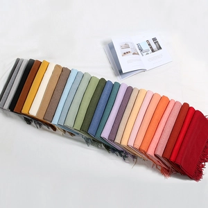 Vista piatta di varie sciarpe in finta cashmere colorata con eleganti frange decorative