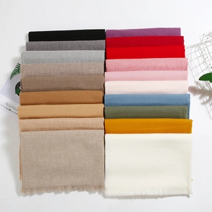 Detailed top view of soft fringe scarves in various solid colors with minimalist props