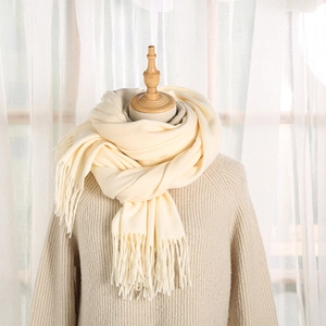 Elegante sciarpa bianco panna stile cashmere con nappe su un manichino di legno