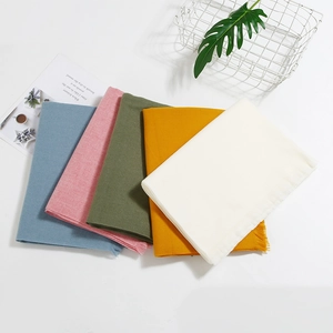 Group of solid colored cashmere-feel scarves with fringe details in various pastel tones
