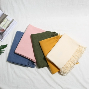 Dettaglio di sciarpe effetto cashmere con frange lunghe in varie tonalità delicate