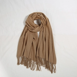 Dettaglio della sciarpa spessa color cammello simil-cashmere con nappe e trama soffice