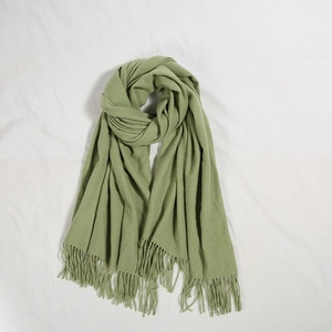 Dettaglio della sciarpa verde effetto cashmere con texture spessa e nappe lunghe
