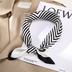 Elegant silk square scarf with black and white stripes on a beige trench coat background