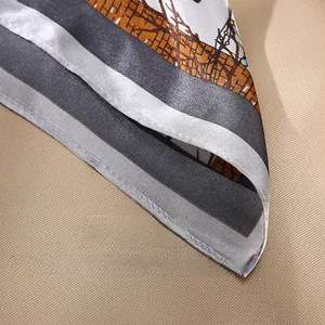 Detailed close-up of neat hem stitching and geometric print on grey silk scarf