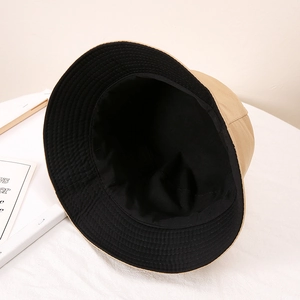 Détail d'un chapeau bob réversible kaki et noir avec des coutures de bordure renforcées