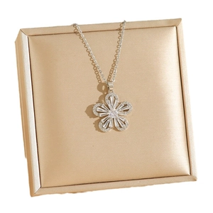 Elegant five-petal flower necklace with zircon stones on a luxury gold jewelry box
