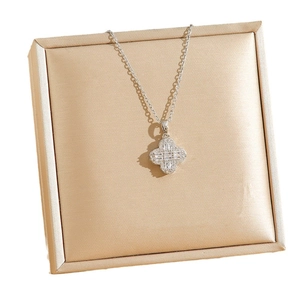 Collier trèfle plaqué or avec diamants scintillants sur support en soie luxueux