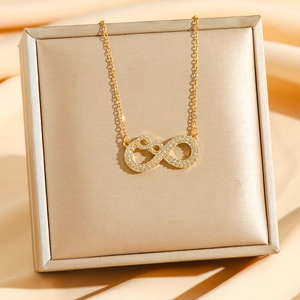 Minimalistische goldene Infinity-Halskette mit Zirkonia auf champagnerfarbener Seide