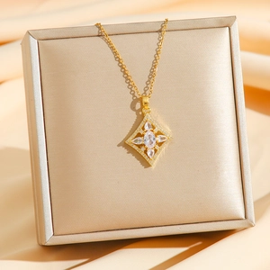 Collier élégant en titane doré avec pendentif géométrique sur un tissu en soie champagne