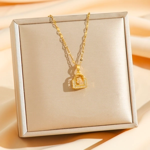 Collier en acier titane doré avec pendentif cadenas et zircon sur tissu satiné