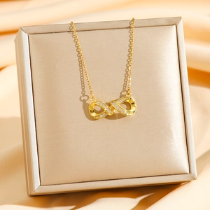 Élégant collier pendentif infini doré avec oxydes de zirconium sur boîte cadeau champagne