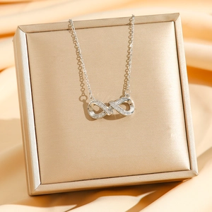 Collier avec pendentif infini en argent et zircons sur un écrin à bijoux doré luxe