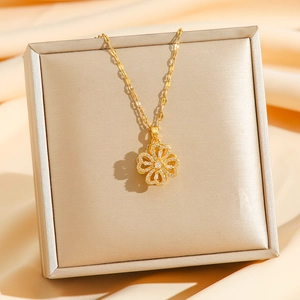 Collier trèfle à quatre feuilles doré rotatif avec zircons sur boîte à bijoux en soie