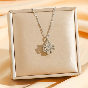 Collier trèfle rotatif en argent avec zircon sur présentoir à bijoux doré de luxe