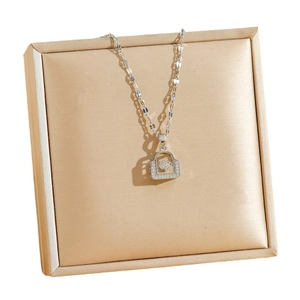 Collier sac à main en argent avec oxydes de zirconium sur présentoir en satin champagne