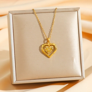 Collier double cœur doré avec cristaux sur support de luxe en soie de champagne