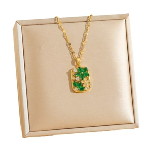 Elegant gold necklace with floral rectangular pendant on satin jewelry box