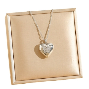 Silver heart locket necklace with zircon butterfly pendant on champagne velvet box
