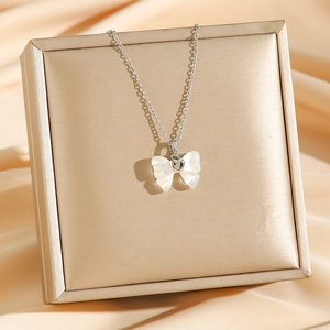 Pendentif papillon en jade sur chaîne en acier titane argenté avec un fond en soie élégant