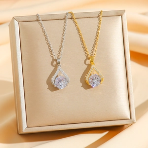 Elegante goldene und silberne Tropfenhalsketten mit Zirkonia-Kristallen auf einer Schmuckbox