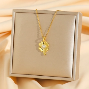 Collier trèfle à quatre feuilles doré avec zircons blancs sur fond de soie rose