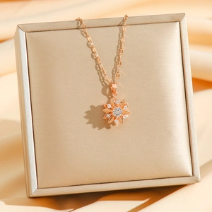 Collier tournesol en or rose avec pendentif en zircon sur un fond de satin élégant