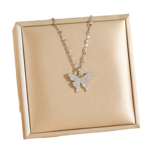 Collier papillon argenté avec zircons et chaîne fine dans une boîte à bijoux de luxe