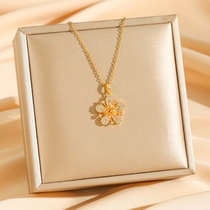 Elegant gold flower necklace with pavé zircon stones on luxury champagne silk display
