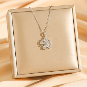 Elegant silver flower necklace with sparkling zircons on champagne silk display