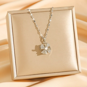 Rotating four-leaf windmill pearl necklace with zircon inlay on luxury satin background
