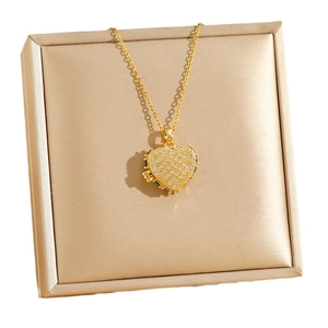 Collier médaillon coeur doré avec zircons colorés sur boîte à bijoux