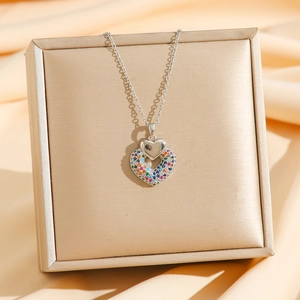 Detail of silver double heart necklace with multi-colored crystals on silk background