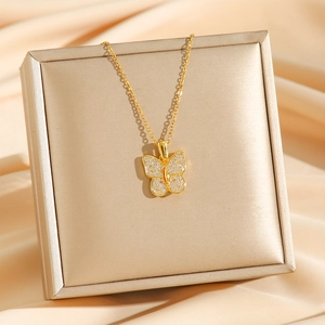 Collier papillon doré serti de zircons blancs sur un coffret à bijoux en satin champagne