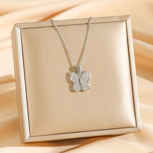 Collier papillon argenté avec pendentif en zircons sur un coffret cadeau élégant