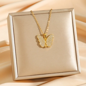 Golden butterfly necklace with white zircon pavé wings displayed on a premium jewelry box