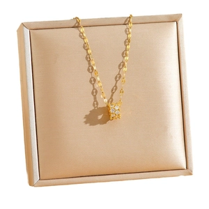 Elegant gold cylinder pendant necklace with sparkling pavé crystals on champagne silk