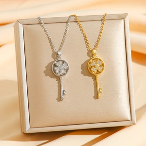 Rotating four-leaf clover key pendant necklace with zircon inlay in gold and silver finish