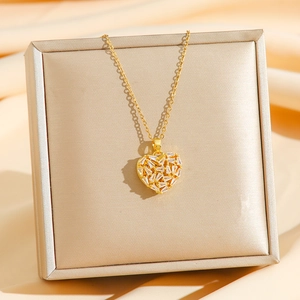 Elegant gold heart pendant necklace with zircon stones on a champagne gift box